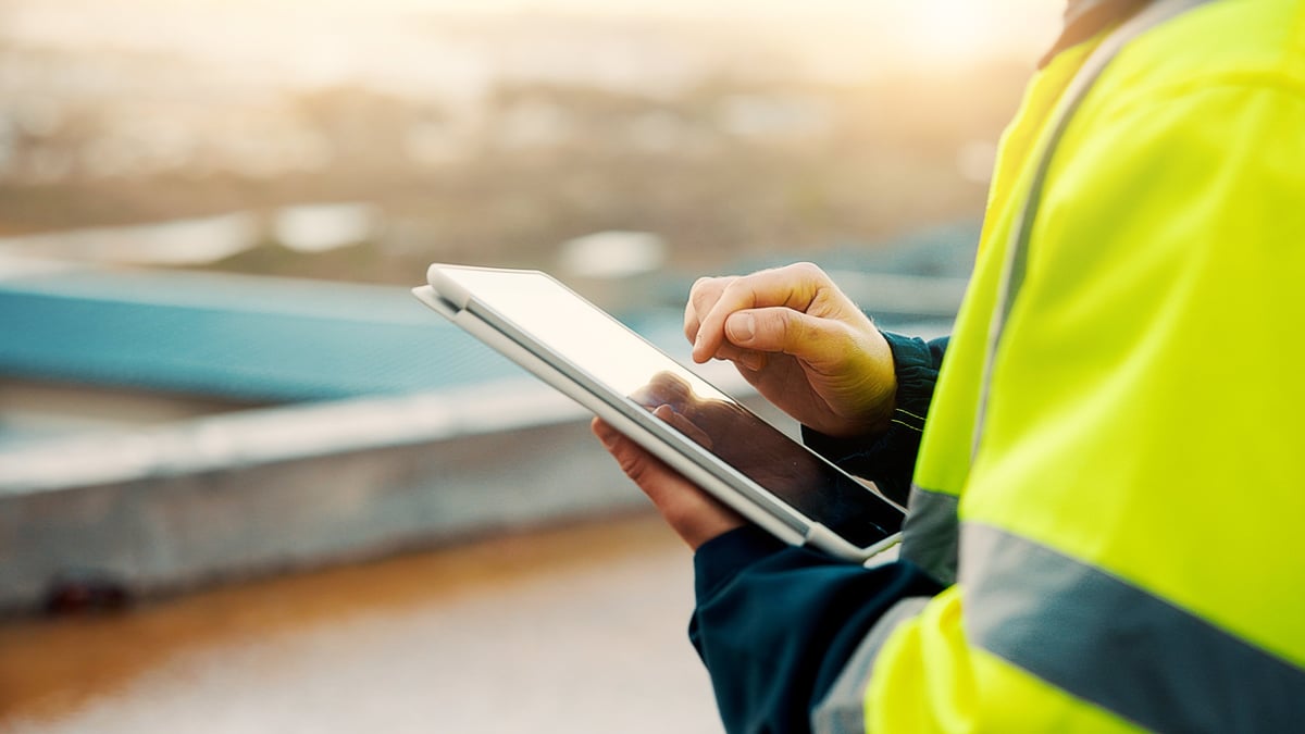 Contractors reviewing a project plan on a tablet at a construction site